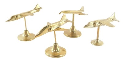 Four aeronautical brass desk stands, comprising a Harrier, two further jet planes and a Concorde.