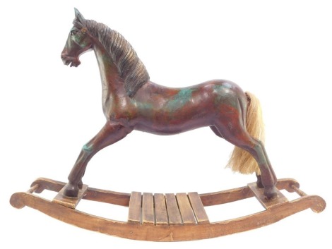 A vintage style carved wooden rocking horse, with horse hair tail, raised on a sleigh type base, 60cm high, 82.5cm wide.