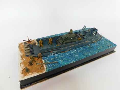 A part scratch built model of a US WWII landing craft, with a Sherman tank, soldiers and other figures, on naturalistic shoreline base, 61cm wide.