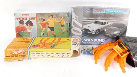 A Hot Wheels loop the loop, air fix football game, and a micro Scalextric James Bond Austin Martin DB5 and Austin Martin DBS action set, boxed.