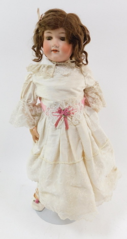 An Armand Marseille bisque headed doll, number 390, A7M, modelled open mouthed, with brown eyes, jointed limbs, on a metal stand, 59cm high.