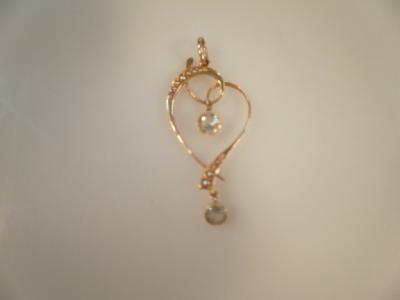 An Edwardian open heart shaped pendant with two aquamarine accents and