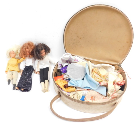 Two Sindy dolls, a further doll, and various clothing and accessories, in a vanity case.