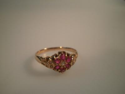 A Victorian style floral cluster ring set with small rubies and diamonds in yellow metal