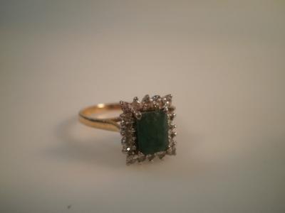 An emerald and diamond cluster ring