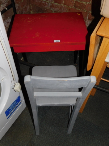 A child's wooden desk, painted red and black, together with a chair painted grey. (2)