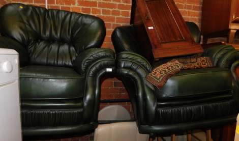 A pair of green leather armchairs.