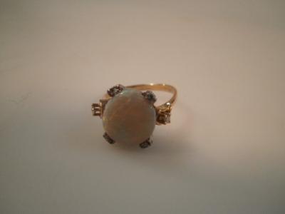 A cabochon opal ring set with tiny diamonds to the mount