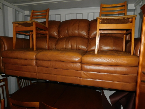 A tan leather three seater sofa.