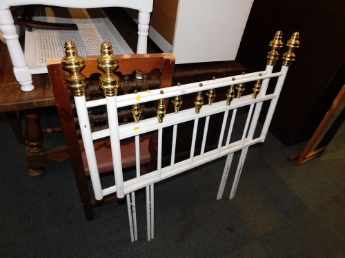 A pair of single metal and brass headboards.