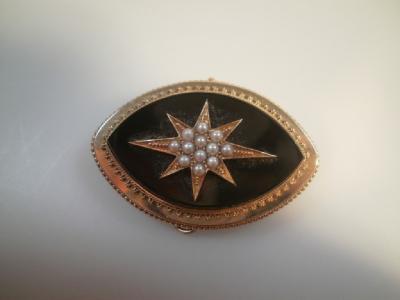 A Victorian memorial brooch with seed pearl set star to the front