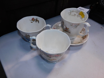 Three Royal Doulton Bunnykins tea cups, to include The Birthday., The Dairy., and The Birthday with matching tea cup. (4)