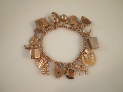 A 9ct gold curb link charm bracelet with twenty attached charms including