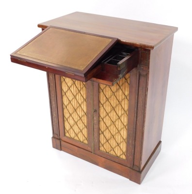 A Regency rosewood secretaire chiffonier, the secretaire drawer opening to reveal a tooled leather ratchetted writing slope flanked by a pen tray and recesses for ink wells and writing accoutrements, above a pair of doors with brass grilled silk fabric ba