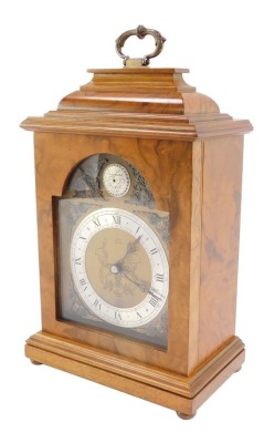 An Elliott mid century walnut cased mantel clock, break arch tempus fugit dial, with chapter ring bearing Roman numerals, clockwork movement, the case of conventional form, with brass carrying handle, raised on brass bun feet, for Usher of Lincoln, 30cm h