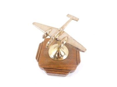 A brass desk stand modelled as a World War II bomber plane, raised on a shaped oak base, 19cm wide. - 2