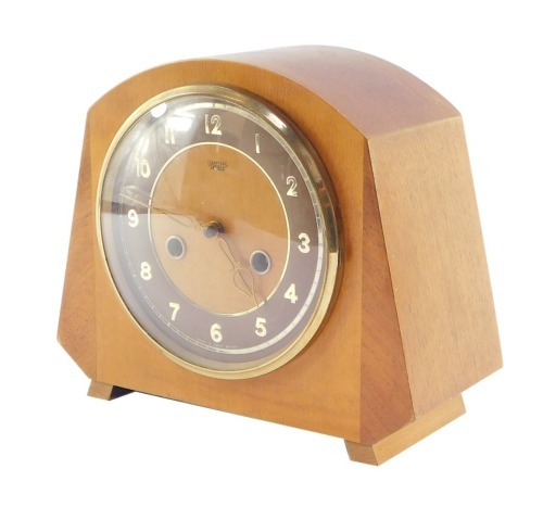A Smiths Enfield mid century mantel clock, circular dial with brown chapter ring bearing Arabic numerals, eight day movement with coil strike, wooden case, with pendulum and key, 21cm high, 25cm wide.