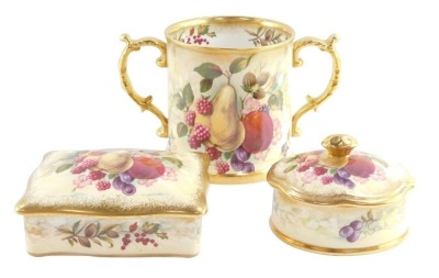 A Hammersley porcelain loving cup, decorated by D Millington with fruit, signed, together with a similar rectangular box and cover and a lobed oval box and cover, printed marks. (3)