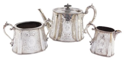 A Victorian silver plated three piece tea set, with foliate scrolled engraving, oval reserve, monogram engraved, comprising teapot, cream jug and sugar bowl.