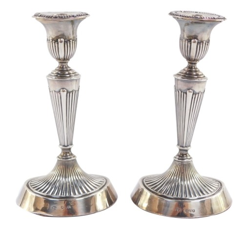 A pair of Victorian loaded silver Adam style candlesticks, of fluted oval form, William Aitken, Chester 1900, 19cm high, 17.5toz all in.