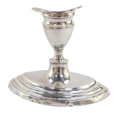 A George V silver candlestick of elliptical form raised on a stepped base, Chester 1913, 10.5cm high, 9.0toz all in.