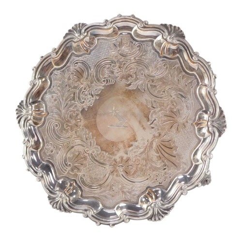 A Victorian silver plated salver, for Thomas's of Bond Street, engraved centrally with a crest within a floral and foliate surround, gadrooned border, raised on three scroll feet, etched marked, 26.5cm diameter.