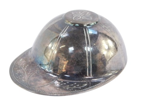 A silver caddy spoon modelled as a jockey's cap, London 1976, 0.5toz.