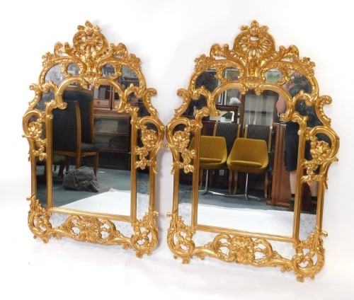 A pair of Belgian rococo style gilt wall mirrors, with seed scroll and floral decoration, 144cm high, 95cm wide.