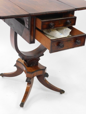 A Regency rosewood drop leaf work table, with two frieze drawers, raised on a U shaped support, over a quatrefoil base above out swept legs, brass paw capped on castors, 75cm high, 36cm wide, 72.5cm extended, 56cm deep. - 4