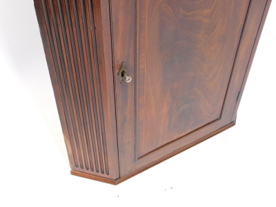 A Georgian style mahogany and boxwood line inlaid hanging corner cupboard, early 20thC, the broken neck pediment, above dentil moulding over a paneled door, opening to reveal three shaped shelves, flanked by channeled sides, 125cm high, 81cm wide, 48cm de - 3