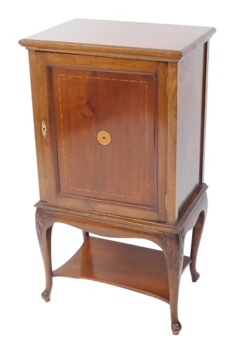 An Edwardian mahogany and inlaid side cabinet, with a single panelled door opening to reveal two shelves, over leaf carved cabriole legs united by a shaped under tier, 94.5cm high, 51cm wide, 36cm deep.