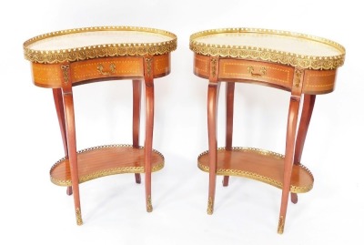A pair of French Louis XV style mahogany and crossbanded kidney shaped gueridons, with brass framed marble tops, over a single frieze drawer, raised on slender cabriole legs, brass capped, united by undertiers, 75cm high, 58cm wide, 35cm deep.