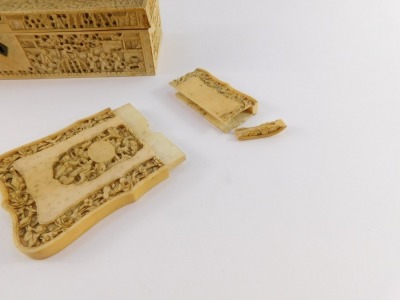 A Cantonese late 19thC ivory box, of rectangular section, carved in bas-relief with figures in a garden, 23.5cm wide, together with a Cantonese Ivory calling card case, decorated with figures within a border of flowers, 7.5cm high (AF), and an ivory lette - 5