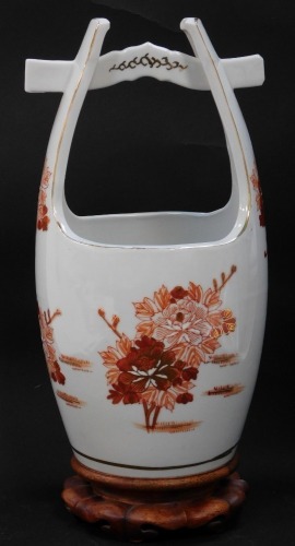 A Japanese porcelain bucket, possibly Arita, decorated in iron red and gold with floral sprays, character seal mark, on a wooden stand, 35cm high.