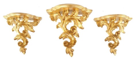 Three giltwood rococo style wall shelves, with serpentine shaped shelves over foliate scroll supports, 20cm high.