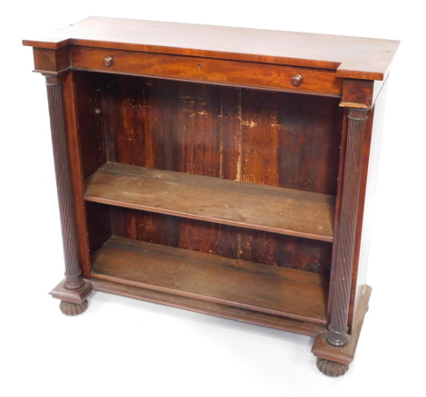 A George IV mahogany breakfront open bookcase, with a single frieze drawer above two shelves, raised on a plinth base united by spiral fluted columns, on fluted bun feet, 96cm high, 106cm wide, 40.5cm deep.