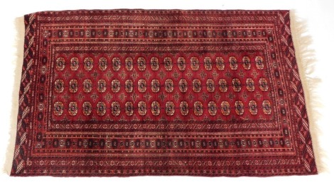 A Bokhara rug, decorated centrally with three rows of sixteen gulls against a red field, within repeating borders, 200cm x 100cm.