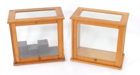 A pair of oak cabinets, for chemist scales, by Philip Harris Limited, Birmingham, with glazed sides and lift up front, raised on rubber feet, 3cm high, 46cm wide, 25.5cm deep.