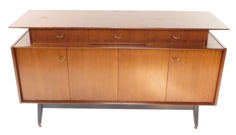 A G-Plan 1950's teak sideboard, designed by E Gomme, with three recessed drawers above a pair of levered drawers, raised on ebonised legs, brass capped, 84cm high, 149cm wide, 45.5cm deep.