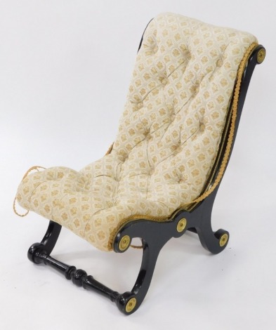 A Victorian ebonised child's X frame chair, with a scroll back, with buttoned floral over stuffed upholstery, raised on X frame supports, united by turned stretchers.