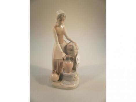 A Nao by Lladro large figurine of a lady filling an amphora jug at a water fountain