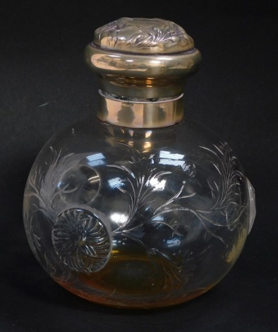 An Edward VII cut glass scent bottle, with silver mount and hinged lid, embossed with flowers, shield reserve monogram engraved, William Comyns and Sons Limited, London 1901.