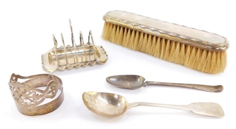 A Victorian silver miniature four division toast rack, Birmingham 1898, Victorian napkin ring of coronet form, Sheffield 1968, George IV Irish Britannia standard silver teaspoon, Dublin 1826, 2.6toz, together with a George V silver backed clothes brush, B
