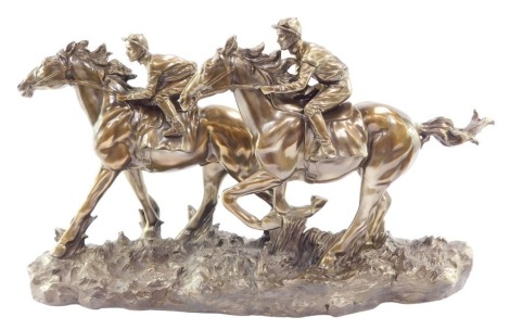 A Fairestware Academy bronzed plaster sculpture of two horse and jockeys, at the gallop, raised on a naturalistic ground, 56cm wide.