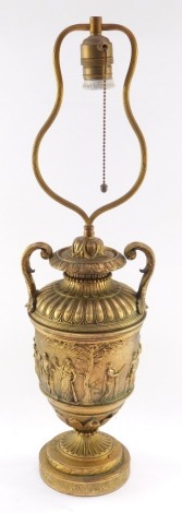 A neoclassical late 19thC loaded brass table lamp, of twin handled semi fluted urn form, decorated centrally with a frieze embossed with classical muses and cherubs, 59cm high.