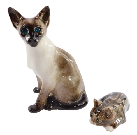 A Winstanley pottery figure of a Siamese cat, modeled seated, with blue glass eyes, 31cm high (AF), together with a Winstanley kitten, modeled in recumbent pose, with yellow glass eyes, 19cm wide. (2)