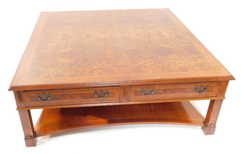 A burr walnut mahogany and herringbone inlaid rectangular coffee table, with two frieze drawers, raised on stile legs, united by shaped under tier, 45cm high, 122cm diameter.