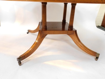 A Bevan & Funnel Limited burr oak circular dining table, raised on four turned column supports above an under tier over four out swept legs, brass caps on casters, 70cm high, 182cm diameter. - 3