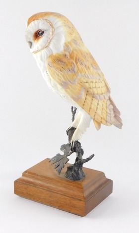 A David Friar porcelain figure of a barn owl, for Royal Worcester, modelled on a metal branch and wooden base, 24.5cm high.