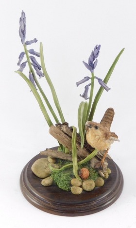 A Country Artists sculpture of a wren, amongst lavender, raised on a stepped circular base.